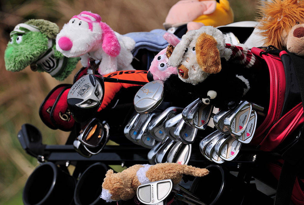 Golf bags filled with clubs and club head covers